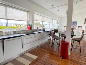 a kitchen with white cabinets and a red trash can at Villa Santec in Santec