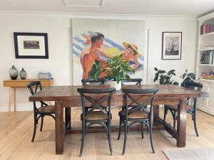 una mesa de comedor con sillas y una pintura en Cosy Guesthouse in Moss Vale, en Moss Vale