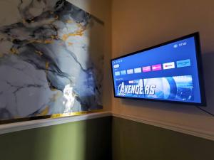 a flat screen tv on a wall with a map at Alap Stay-Inn in Candi