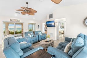 a living room with blue couches and a ceiling fan at 3435 S Highway A1A in Melbourne Beach