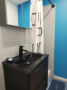 a bathroom with a black sink and a shower curtain at Chez Pierre in Narbonne