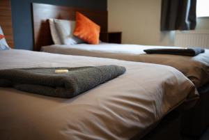 - 2 lits dans une chambre d'hôtel avec une serviette dans l'établissement The Fitzwilliam Hotel, à Rotherham