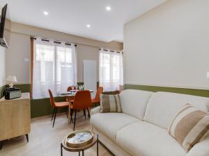 a living room with a white couch and a table at En Centre ville Gare et commerces in Vincennes