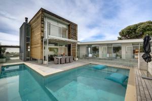 a swimming pool in front of a house at The Whyte House - Waimarama Beachfront in Waimarama