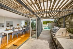 an open kitchen and dining room with a table and chairs at The Whyte House - Waimarama Beachfront in Waimarama