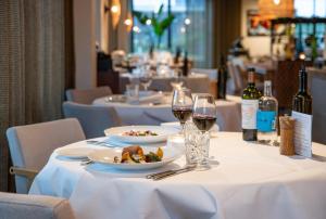 a table with white plates of food and wine glasses at Lodge in Loosdrecht-Amsterdam in Loosdrecht