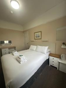 a bedroom with a large white bed and a sink at Clarence House Hotel in Tenby