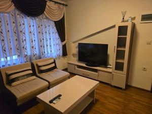 a living room with a couch and a flat screen tv at Стаи за гости Дани in Zlatograd