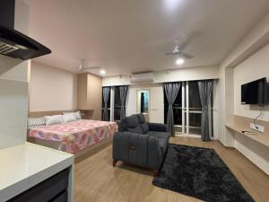 a bedroom with a bed and a couch and a chair at Aura Living in Pune