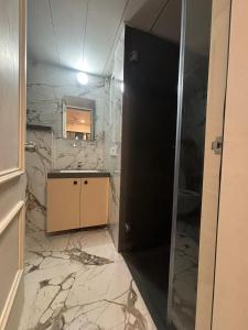 a bathroom with a sink and a mirror and marble walls at Aura Living in Pune