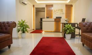 a lobby with a red carpet and a red rug at Broadway Inn in Mysore
