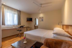 a hotel room with a bed and a desk at Best Western Nairobi Upper Hill in Nairobi