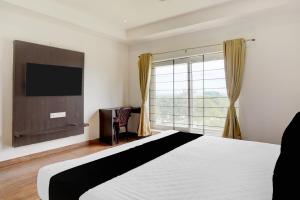 a bedroom with a bed and a large window at Super Collection O Nandagokula Convention Centre Formerly Arasu Comforts in Hassan