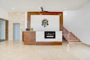 a lobby with a sign on the wall and stairs at Super Collection O Nandagokula Convention Centre Formerly Arasu Comforts in Hassan