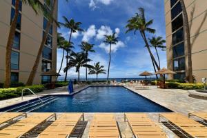 カハナにあるMahana 713 · MA 713 Luxury OceanFront Studioのヤシの木と海のスイミングプール