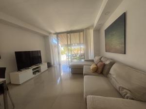 a living room with a couch and a flat screen tv at Relax Blue Marlin Pasito Blanco in Pasito Blanco