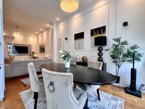 a dining room with a black table and white chairs at Spacious Family Apartment for 9 near Brussels Midi Station in Brussels +90 photos