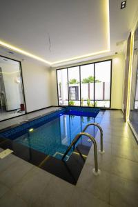 a large swimming pool in a building with windows at شاليهات حياة رويال in Taif