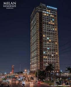 a tall building at night with cars on a street at RR 21 Milan Residenze Fairview in Manila