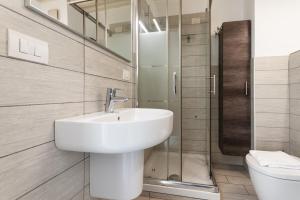 a white bathroom with a sink and a toilet at Youhosty - Bruno Maderna 17 Duplex in Milan +19 photos