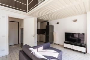 a living room with a couch and a tv at Youhosty - Bruno Maderna 17 Duplex in Milan