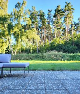 a bench sitting on a patio in front of a park at Deine Ruhe Oase mit Waldblick in Gustow