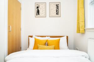 エディンバラにあるElegant 3BR Home, City Centre and Free Parkingの黄色い枕が置かれたベッドのある寝室