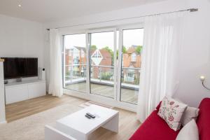 a living room with a red couch and a large window at Marina 24-A in Cuxhaven