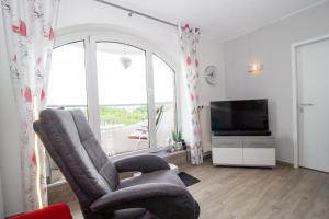 a living room with a chair and a television at Deichgraf 345 in Döse