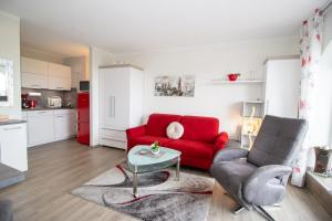 a living room with a red couch and a table at Deichgraf 345 in Döse