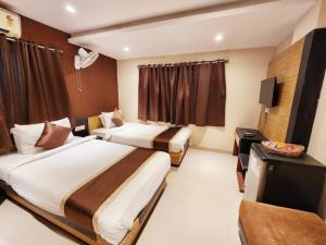 a hotel room with two beds and a television at Hotel Saad in Kolkata +32 photos