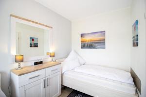 a small bedroom with a bed and a mirror at Deichgraf 345 in Döse