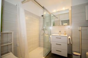 a bathroom with a glass shower and a sink at Deichgraf 345 in Döse +29 photos