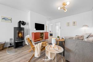 Una sala de estar con un sofá y una chimenea. en Ferienwohnung Sprotte 1, en Olpenitzdorf