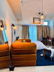 a bedroom with a bed and a couch at Kozy Mood Studio - 19N Renoir in Manila
