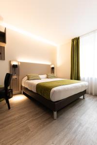 a bedroom with a bed and a window at Hotel Cheval De Bronze in Remiremont