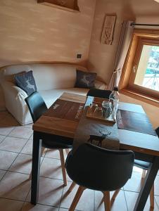 une salle à manger avec une table et un lit dans l'établissement Wood Apartment, à Livigno