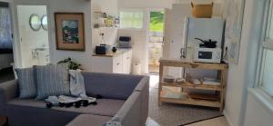 a living room with a couch and a microwave at Dinky's Place in Herolds Bay