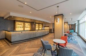 a lobby with a bar and tables and chairs at NYX Hotel Erfurt by Leonardo Hotels in Erfurt +57 photos