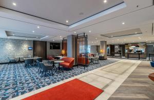 a lobby of a hotel with tables and chairs at NYX Hotel Erfurt by Leonardo Hotels in Erfurt