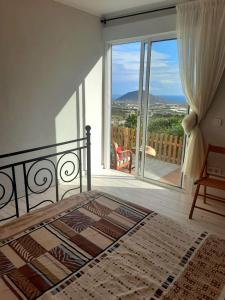 a bedroom with a bed and a large glass window at El jardin de Valle de Guimar in Güimar