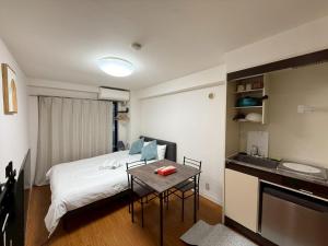 a small room with a bed and a table in it at Nogata House in Tokyo