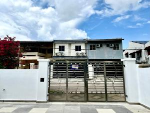 a house behind a gate with a fence at Comfort Homestay JB Town near CIQ in Johor Bahru