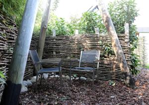 two chairs sitting in front of a wooden wall at Logeerruimte Bij Ton in Beilen +7 photos