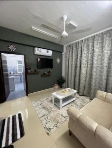 a living room with a couch and a table at شقة البشائر in Al Khawḑ