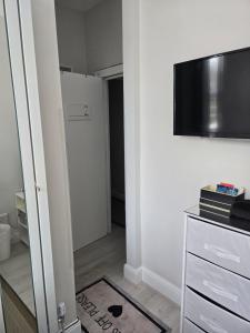 sala de estar con TV y puerta blanca en Sunflower Shared Apartment, en Londres