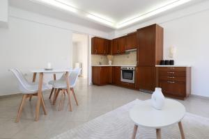 a kitchen with wooden cabinets and a table and chairs at Perdika Residences in Perdika
