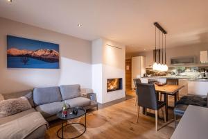 a living room with a couch and a table and a kitchen at das Luis in Oberndorf in Tirol +28 photos