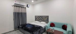a room with a bed and a blue couch at The Western Lodge in Narjon Basti +10 photos