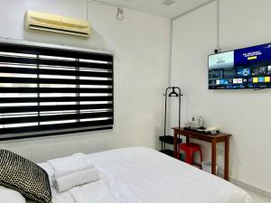 a bedroom with a bed and a window with a tv at Comfort Homestay JB Town near CIQ in Johor Bahru